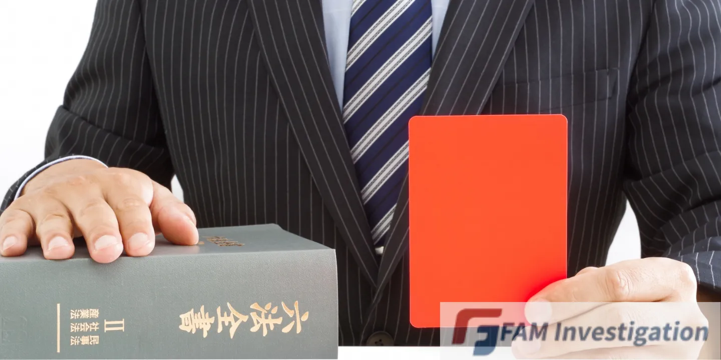 六法全書とレッドカードを手にする弁護士